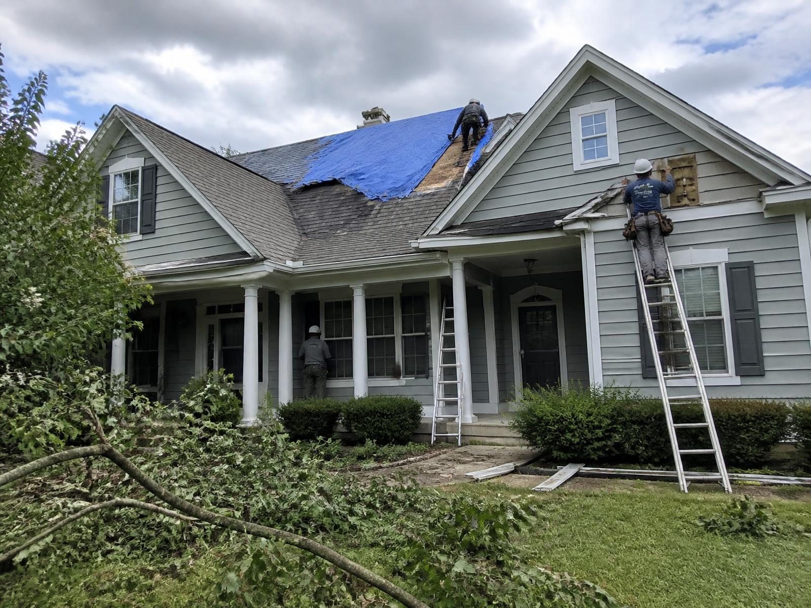 Pro One crew repairing storm-damaged roof and siding on a home in York PA